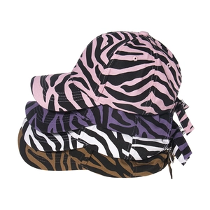 Stack of four zebra print baseball caps showing adjustable metal buckle straps in detail