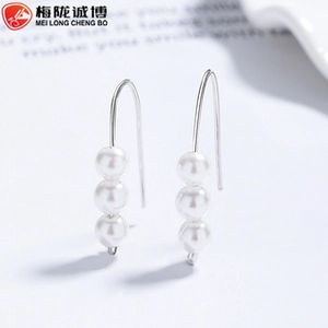 Detail view of 925 sterling silver ear cuffs featuring three elegant white pearls