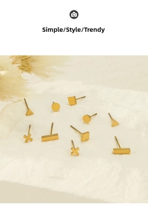 Macro detail of geometric gold stud earrings in various shapes on a stone texture