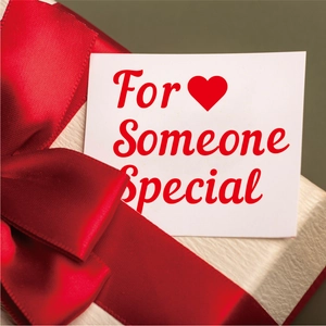 Détail d'un coffret cadeau avec ruban rouge et carte For Someone Special sur papier texturé