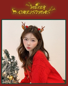 Close-up of reindeer antler hair clips with red plush pom-poms and Christmas tree decor