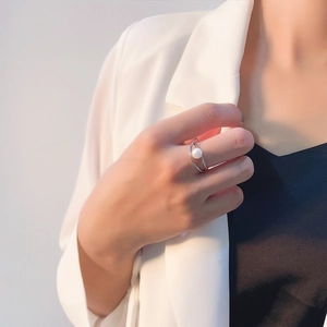 Elegant S925 sterling silver cross ring with white pearl worn by a model in white suit