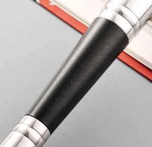 Macro detail of matte black handle and silver metal ferrule on professional makeup brush