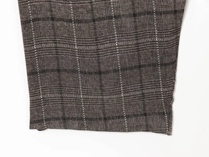Détail du tissu en laine mélangée à carreaux marron et gris avec des coutures précises