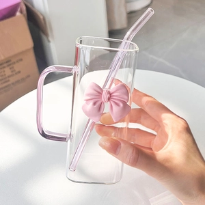 Square glass cup with pink handle and bow detail featuring a clear glass straw