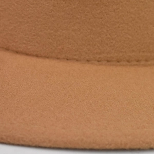 Macro shot of camel wool felt hat showing high-quality stitching and fine fiber texture