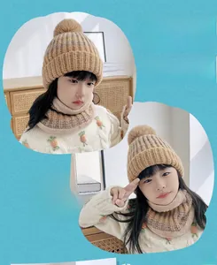 Dettaglio del set cappello e scaldacollo in maglia kaki per bambini con pompon e tessuto caldo