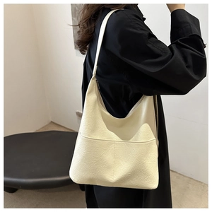 Detail of cream white tote bag showing soft pebbled leather texture and stitching