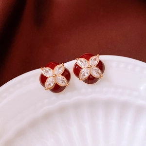 Detail of flower stud earrings with red enamel and white marquise crystals in 18k gold