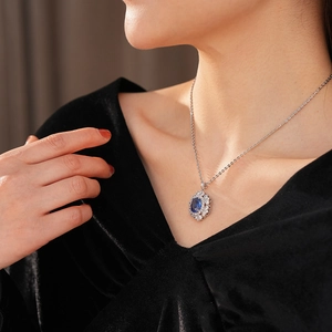 Modella che indossa una collana vintage con pendente ovale blu e catena d'argento