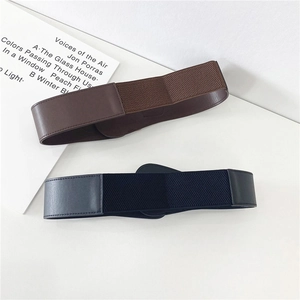 Detail of wide elastic waist belts in black and brown with faux leather accents