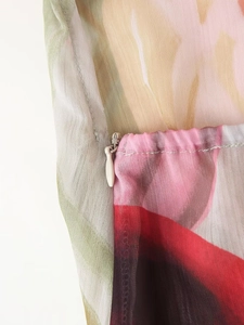 Gros plan sur la fermeture éclair invisible et la texture en mousseline de la robe longue