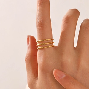 Dreilagige 18K vergoldete Edelstahlringe mit handgehämmerter Textur an der Hand eines Models