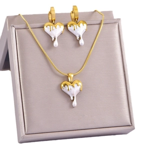 White heart pendant necklace and earrings set in golden frame on champagne satin