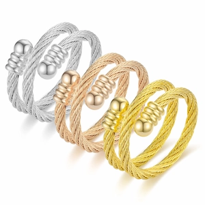 Three twisted wire cuff rings in silver, rose gold and gold finishes on white background