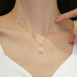 Close-up of gold titanium necklace featuring a sparkling flower pendant with zircons