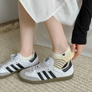 Striped low cut ankle socks with heart embroidery worn with classic sneakers