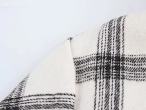 Close-up of high-quality black and white plaid wool texture on jacket collar and shoulder
