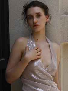 Detail of an 18K gold plated flower ring and pink sequin dress on a fashion model