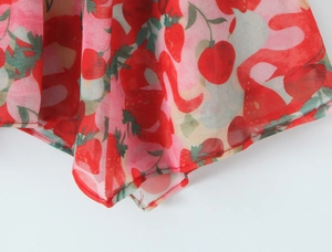 Dettaglio del tessuto in chiffon con vivaci stampe rosse di fragole e mele fresche