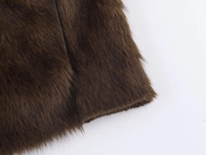 Gros plan sur la texture en fausse fourrure marron foncé et les fibres de cette veste