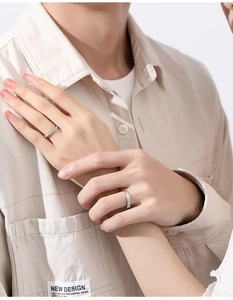 Detail of S925 silver couple rings with minimalist cross design worn on hands