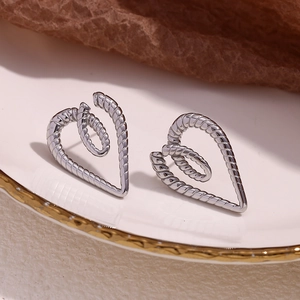 Macro detail of silver twisted rope textured double heart stainless steel earrings