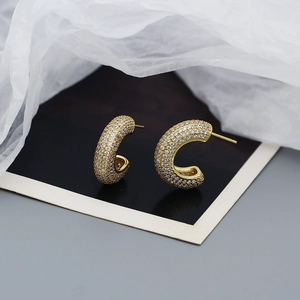 Close-up of gold-plated silver hoop earrings with shimmering cubic zirconia stones