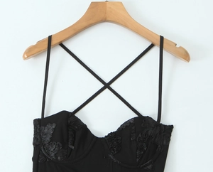 Detail of black corset dress featuring 3D floral embroidery and lace trim on neckline