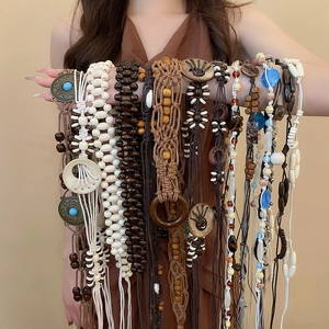 Detail of bohemian handmade beaded waist chains featuring wooden beads and braided cotton rope