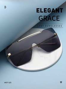 Detailaufnahme einer quadratischen Sonnenbrille mit lila Verlaufsgläsern auf Marmor