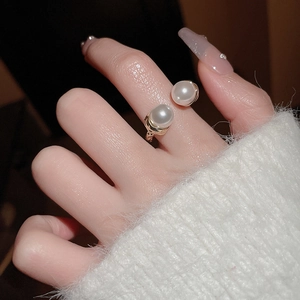 Detail shot of a gold-plated double pearl open ring worn with elegant mohair sweater