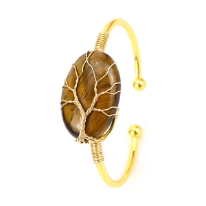 Detail of tiger eye stone cuff bracelet with golden wire-wrapped tree of life design