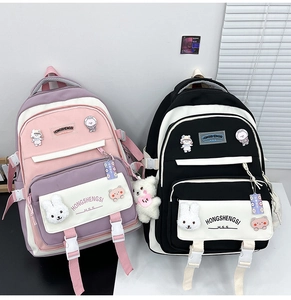 Detail of cartoon backpacks in pink and black colors with cute plush bunny pendants