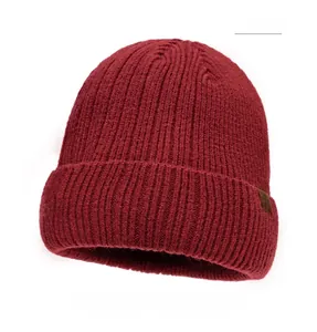 Detailed view of dark red ribbed knit beanie with a brown leather logo patch for winter