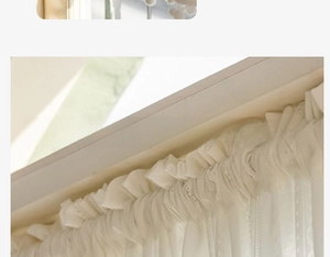 Detail showing white lace curtain with multi-layered ruffled edges and floral embroidery