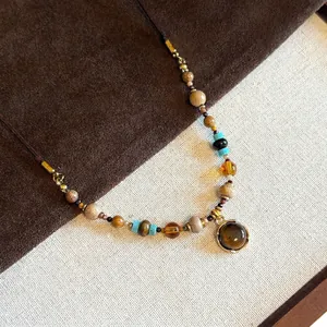 Detailed view of beaded necklace with tiger eye stone pendant and mixed earth tone beads