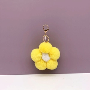 Detail of soft yellow and white plush flower bag charm with golden spring clasp link