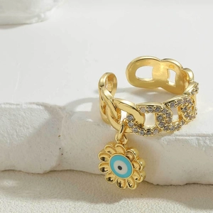 Detailed close-up of a 14K gold plated flower charm ring with blue evil eye zircon stones