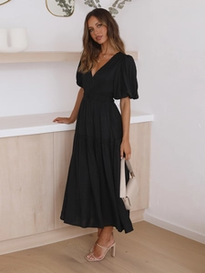 Detail of elegant black V-neck puff sleeve dress with high-waisted tiered skirt design