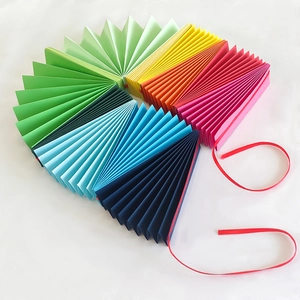 Rainbow fan paper garlands for party decoration with red ribbon on white background
