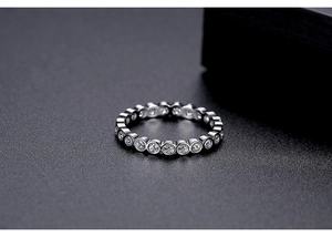 Macro shot of silver eternity ring with bezel-set round cubic zirconia stones