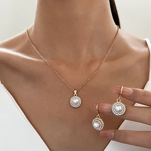 Detail of necklace and earrings set with white pearls and sparkling crystal rhinestones