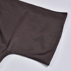 Detail shot of a dark brown sleeve showing fine texture and clean stitching of the set