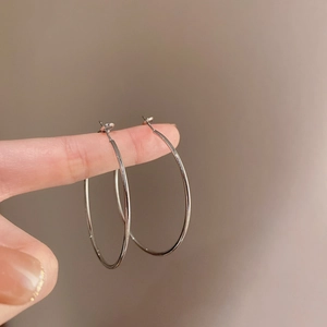 Minimalist large silver metal hoop earrings with a polished finish and simple design