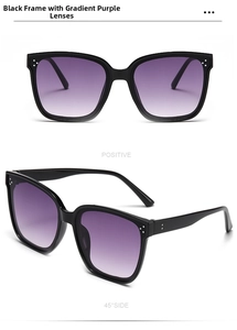 Detail of oversized black sunglasses with gradient purple lenses and silver metal rivets