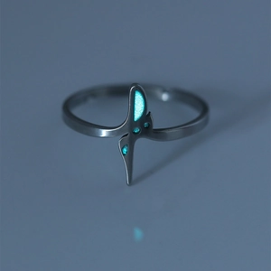 Macro shot of glow-in-the-dark stainless steel ring with luminous blue light detail