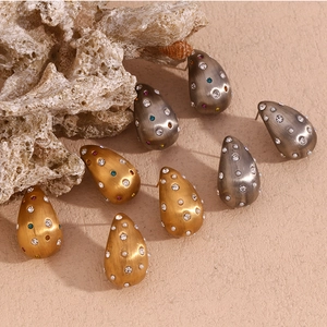 Détails macro de boucles d'oreilles goutte en or 18K brossé avec perles et cristaux colorés