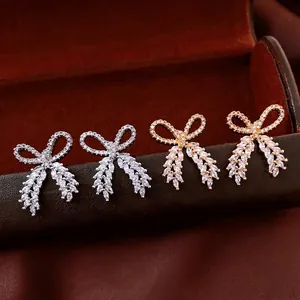 Elegant gold and silver bow earrings with sparkling marquise cut cubic zirconia stones