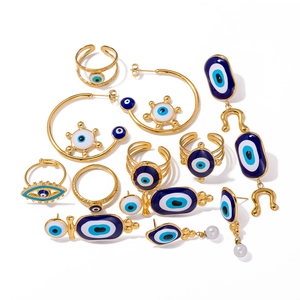 Gold Evil Eye jewelry set featuring blue enamel rings and pearl drop earrings on white background